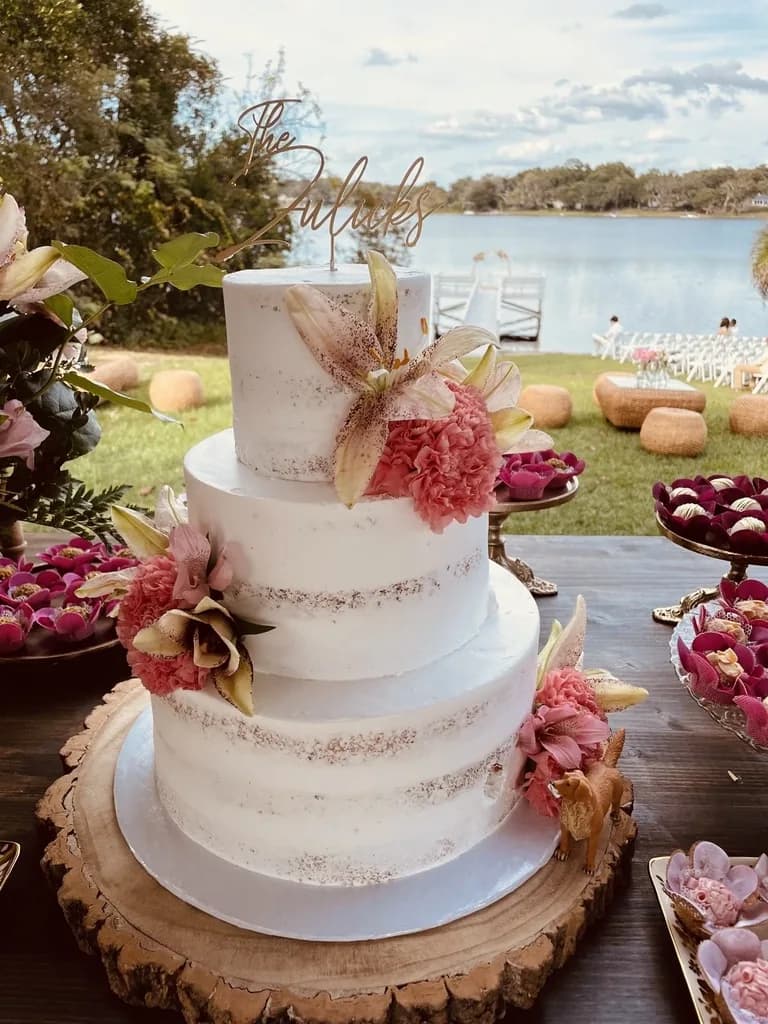 Three-tier semi-naked wedding cake with pink flowers