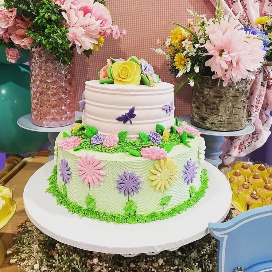 Two-tier garden-themed cake with pastel flowers and butterflies