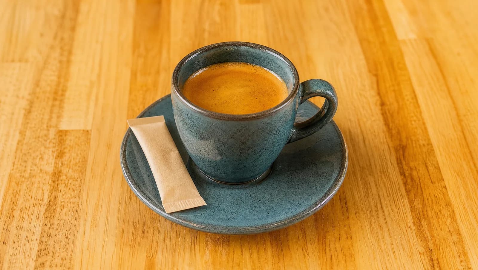 Espresso in a ceramic cup with a sugar stick at Floré Café & Kitchen